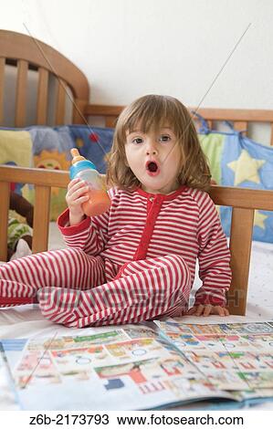 Baby girl, 20 months, Bedroom, Feeding, bottle, juice, pyjamas, Book, crib, shout View Large Photo Image Stock Image - Baby girl, 20 months, Bedroom, Feeding, bottle, juice, pyjamas, Book, crib, shout. Fotosearch