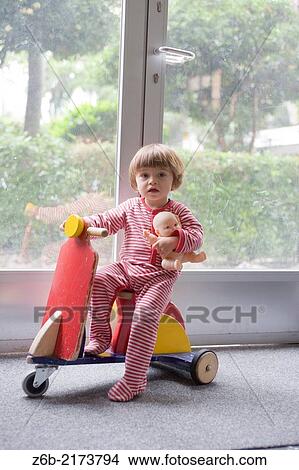 Baby girl, 20 months, Vespa, scooter, Indoors, Door/window, handle, key hole, Doll, wooden toy, Pyjamas View Large Photo Image Picture - Baby girl, 20 months, Vespa, scooter, Indoors, Door/window, handle, key hole, Doll, wooden toy, Pyjamas. Fotosearch