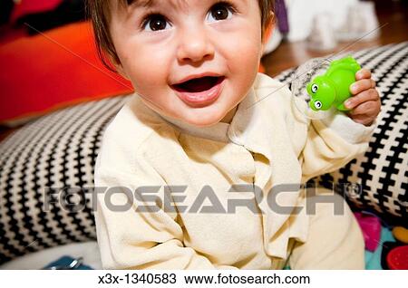 Baby girl holding a frog toy View Large Photo Image Stock Image - Baby girl holding a frog toy. Fotosearch