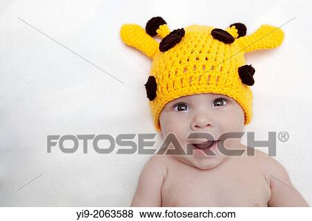 Stock Photo - Baby girl in giraffe hat.. Fotosearch