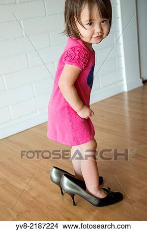 Picture - Baby girl in her mother's shoes.. Fotosearch