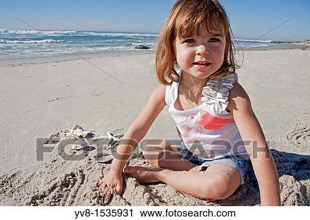 Baby girl playing in the sand View Large Photo Image Stock Image - Baby girl playing in the sand. Fotosearch