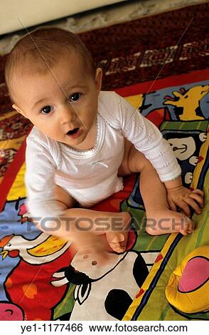 Baby girl playing on a blanket. View Large Photo Image Stock Photograph - Baby girl playing on a blanket.. Fotosearch