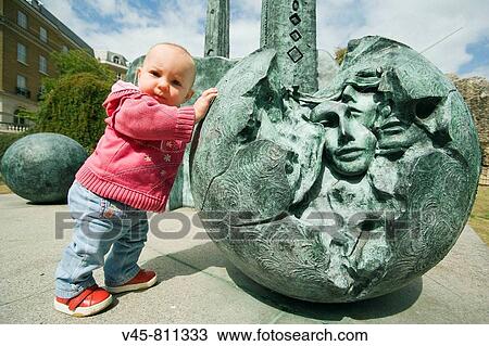 Baby girl pushing a ball of the contemporary sculpture near Reading Abbey Berkshire, England View Large Photo Image Stock Image - Baby girl pushing a ball of the contemporary sculpture near Reading Abbey Berkshire, England. Fotosearch