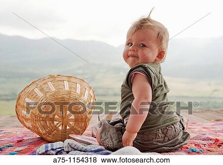 Baby girl sitting on the ground, looking back View Large Photo Image Stock Photo - Baby girl sitting on the ground, looking back. Fotosearch