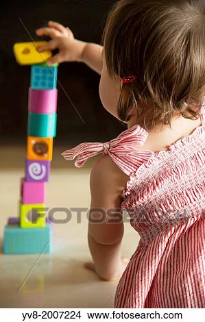 Baby girl skillfully balancing wooden blocks. View Large Photo Image Picture - Baby girl skillfully balancing wooden blocks.. Fotosearch