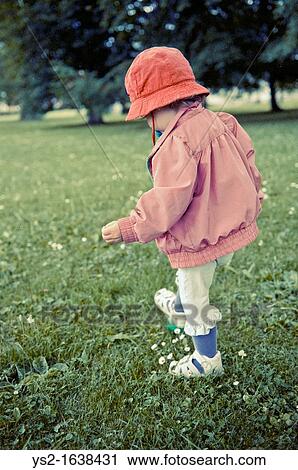 Stock Image - Baby girl walking in a park. Fotosearch