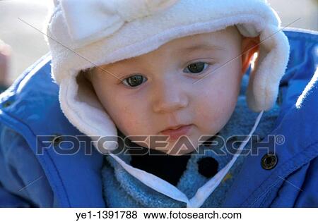 Stock Photo - Baby girl wearing winter clothes outdoors, France. Fotosearch