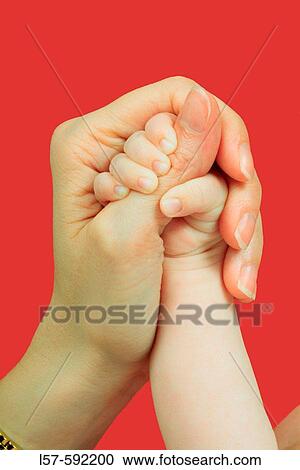 Stock Image - Baby hand holding parent's hand. Fotosearch