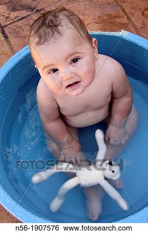 Stock Photograph - Baby having a Summer bath. Fotosearch