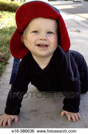 Stock Photograph - baby in hat crawling outside. Fotosearch