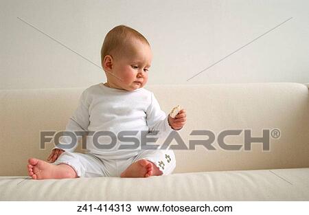 Baby looking at rice-cracker View Large Photo Image Stock Image - Baby looking at rice-cracker. Fotosearch