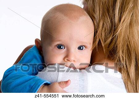 Stock Image - Baby looking over mothers shoulder.. Fotosearch