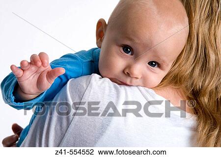 Stock Image - Baby looking over mothers shoulder.. Fotosearch