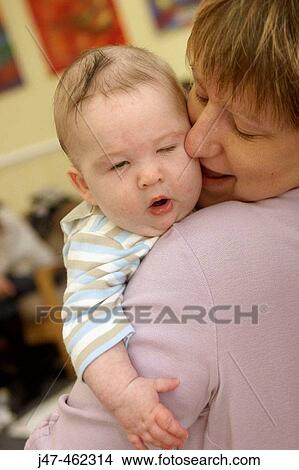 Baby lying on her mothers shoulder yawning. View Large Photo Image Picture - Baby lying on her mothers shoulder yawning.. Fotosearch