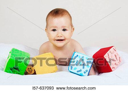 Baby lying on tummy, playing with toy, studio, Oetwil am See, Zuerich, Switzerland View Large Photo Image Stock Image - Baby lying on tummy, playing with toy, studio, Oetwil am See, Zuerich, Switzerland. Fotosearch
