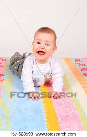 Baby lying on tummy, smiling, Studio, Oetwil am See, Zuerich, Switzerland View Large Photo Image Stock Image - Baby lying on tummy, smiling, Studio, Oetwil am See, Zuerich, Switzerland. Fotosearch