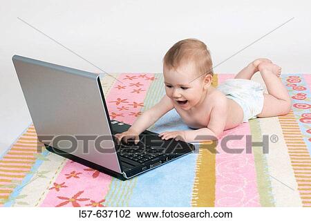Baby lying on tummy, wearing nappies, playing with laptop computer, Studio, Oetwil am See, Zuerich, Switzerland View Large Photo Image Stock Image - Baby lying on tummy, wearing nappies, playing with laptop computer, Studio, Oetwil am See, Zuerich, Switzerland. Fotosearch