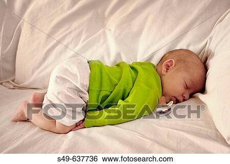 Stock Photograph - Baby napping on sofa. Fotosearch