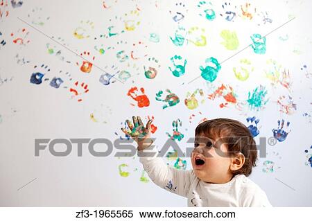 Baby painting a white wall with his hands View Large Photo Image Stock Photography - Baby painting a white wall with his hands. Fotosearch