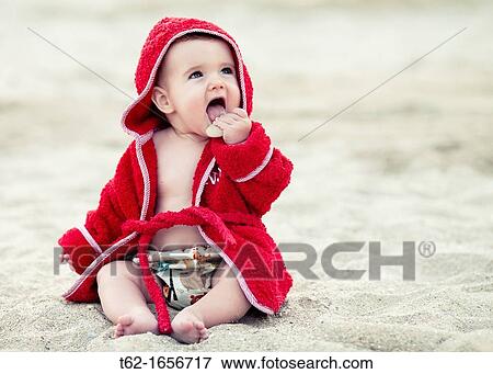 Baby playing on the beach View Large Photo Image Stock Photo - Baby playing on the beach. Fotosearch