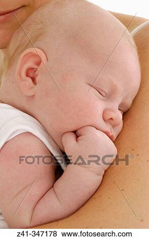 Baby resting on mum's arms View Large Photo Image Stock Photo - Baby resting on mum's arms. Fotosearch