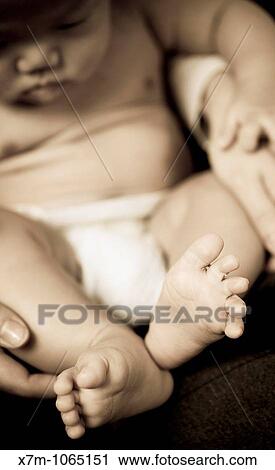Stock Image - Baby sitting in parents? lap. Fotosearch