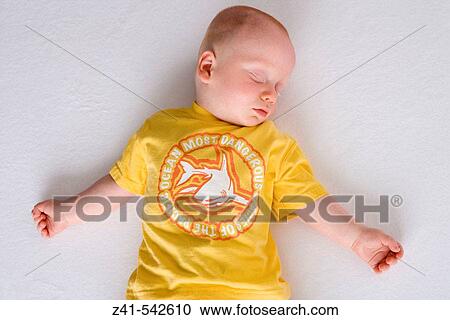 Stock Image - Baby sleeping on the floor.. Fotosearch
