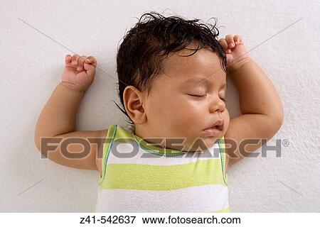 Stock Photo - Baby sleeping on the floor.. Fotosearch