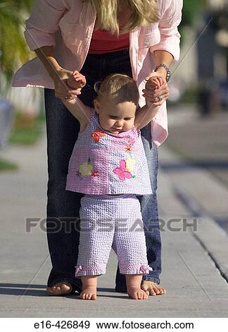Baby steps with helping mother View Large Photo Image Stock Photo - Baby steps with helping mother. Fotosearch