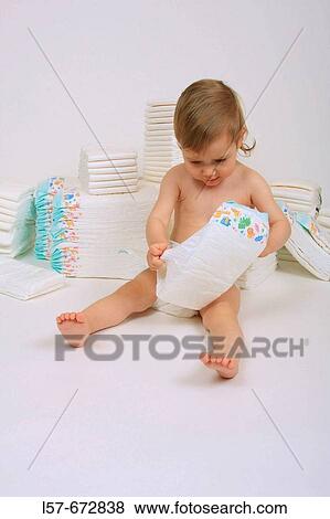 Baby wearing nappies, sitting and playing with nappies, pile of nappies View Large Photo Image Stock Photo - Baby wearing nappies, sitting and playing with nappies, pile of nappies. Fotosearch