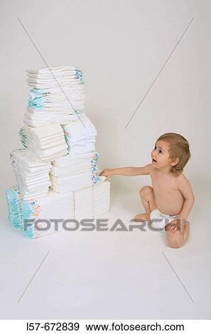 Baby wearing nappies, sitting and playing with nappies, pile of nappies View Large Photo Image Stock Photo - Baby wearing nappies, sitting and playing with nappies, pile of nappies. Fotosearch