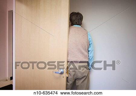 Back of a man standing by a door in an office building lobby View Large Photo Image Picture - Back of a man standing by a door in an office building lobby. Fotosearch