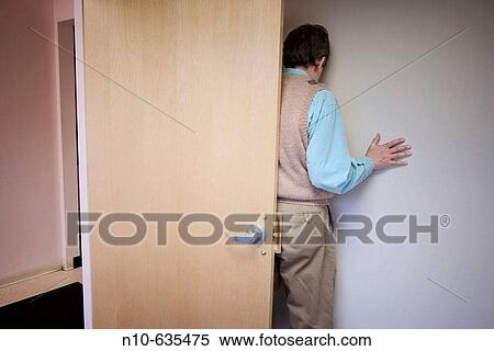 Back of a man standing by a door in an office building lobby View Large Photo Image Stock Photography - Back of a man standing by a door in an office building lobby. Fotosearch