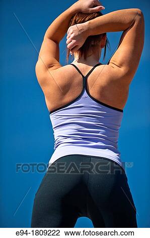 Back view of a 23 year old brunette woman in workout clothing outdoors against a blue sky View Large Photo Image Stock Image - Back view of a 23 year old brunette woman in workout clothing outdoors against a blue sky. Fotosearch