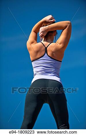 Back view of a 23 year old brunette woman in workout clothing outdoors against a blue sky View Large Photo Image Stock Image - Back view of a 23 year old brunette woman in workout clothing outdoors against a blue sky. Fotosearch