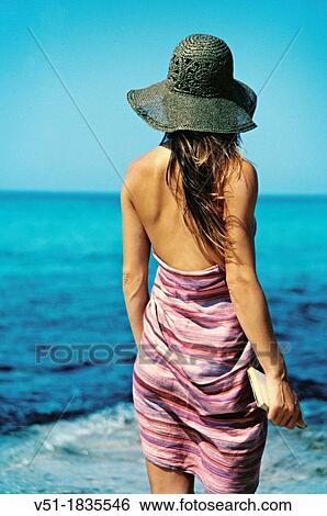 Back View of a brunette woman with book looking at the sea View Large Photo Image Stock Photograph - Back View of a brunette woman with book looking at the sea. Fotosearch