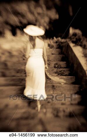 Back view of a woman in a white dress walking up a stairway, outdoors View Large Photo Image Stock Photo - Back view of a woman in a white dress walking up a stairway, outdoors. Fotosearch