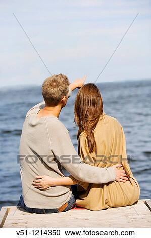 Back view of a young cople sitting in a pier View Large Photo Image Stock Image - Back view of a young cople sitting in a pier. Fotosearch