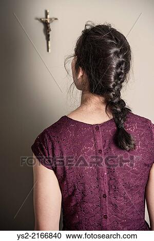 Back view of woman looking at crucifix hanging on wall. View Large Photo Image Stock Image - Back view of woman looking at crucifix hanging on wall.. Fotosearch