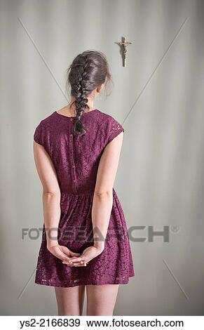 Back view of woman looking at crucifix hanging on wall. View Large Photo Image Stock Photo - Back view of woman looking at crucifix hanging on wall.. Fotosearch