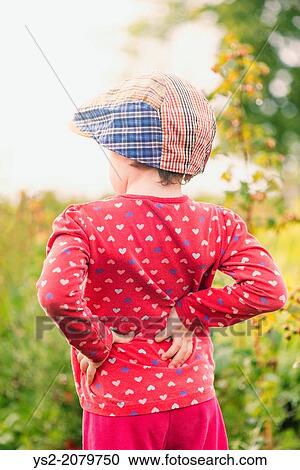 Back view of young child standing in garden watching green plants and flowers. View Large Photo Image Stock Image - Back view of young child standing in garden watching green plants and flowers.. Fotosearch