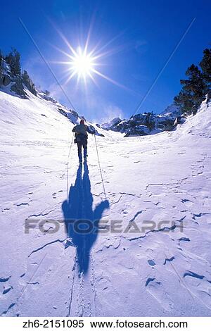 Stock Photography - Backcountry skier crossing wind blown snow near Treasure Lakes, John Muir Wilderness, California USA.. Fotosearch