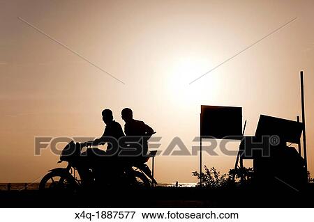 Backlight of a motorcycle with two people on the beaches of allepy View Large Photo Image Stock Photo - Backlight of a motorcycle with two people on the beaches of allepy. Fotosearch