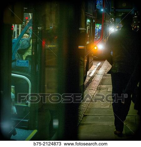 Backlight of a rear view of a man walking behind a double decker bus in London, England, UK View Large Photo Image Stock Image - Backlight of a rear view of a man walking behind a double decker bus in London, England, UK. Fotosearch