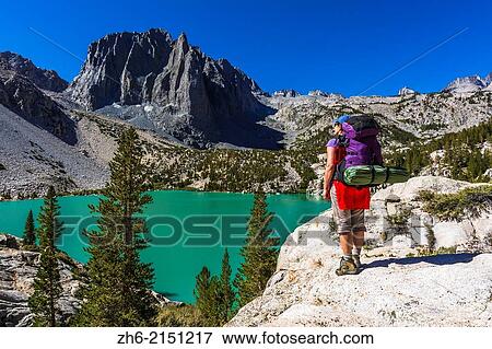 Stock Photo - Backpacker at Second Lake under Temple Crag and the Palisades, John Muir Wilderness, California USA.. Fotosearch