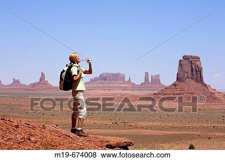 Stock Photo - Backpacker drinking water in Monument Valley. Arizona, USA. Fotosearch
