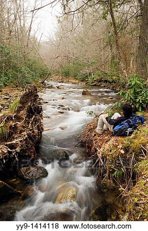 Stock Photo - Backpacker resting by the Davidson River - Pisgah National Forest - near Brevard, North Carolina, USA. Fotosearch
