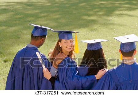 Stock Image - Backview of college graduates with female graduate looking back over her shoulder. Fotosearch