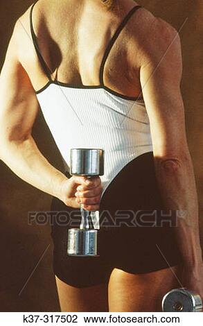 Stock Image - Backview of woman holding free weight. Fotosearch